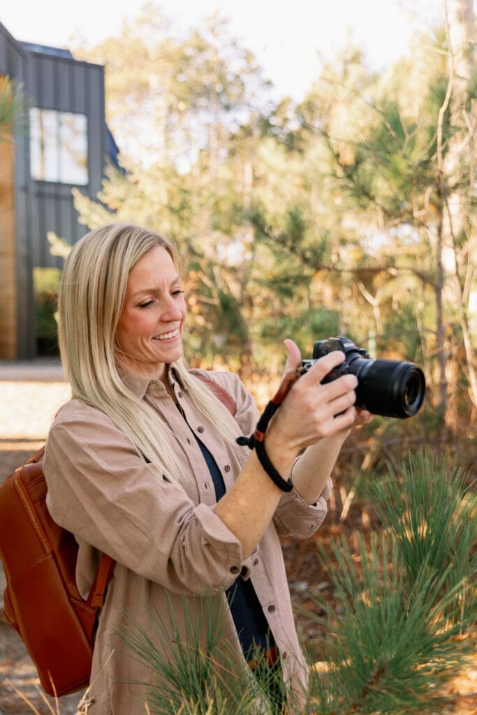 Portrait photographer adjusting camera settings while learning shutter speed for sharp, professional portraits.
