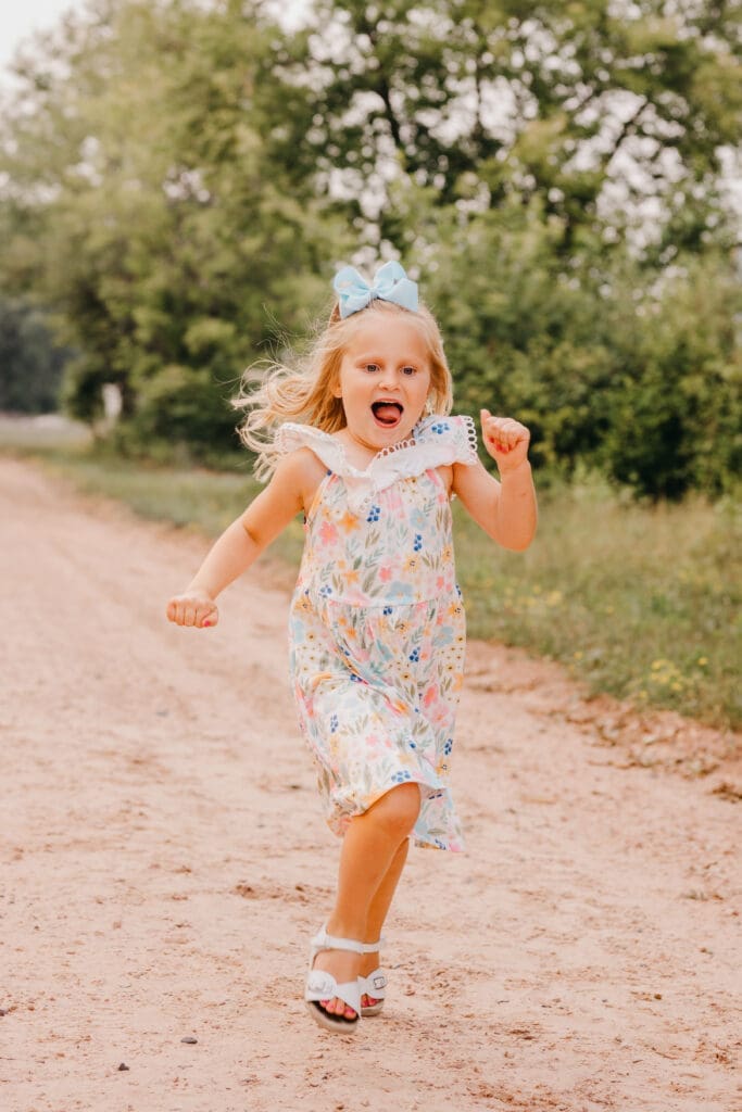 Children running and playing outdoors during a family photography session with motion frozen using a fast shutter speed.