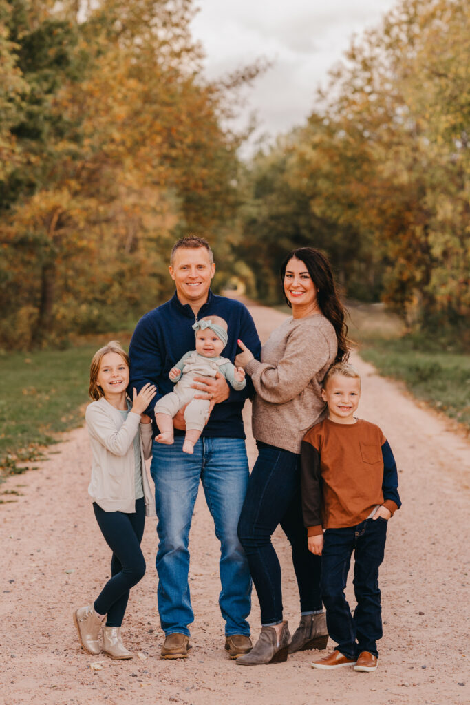Photographer posing a young family during an outdoor session