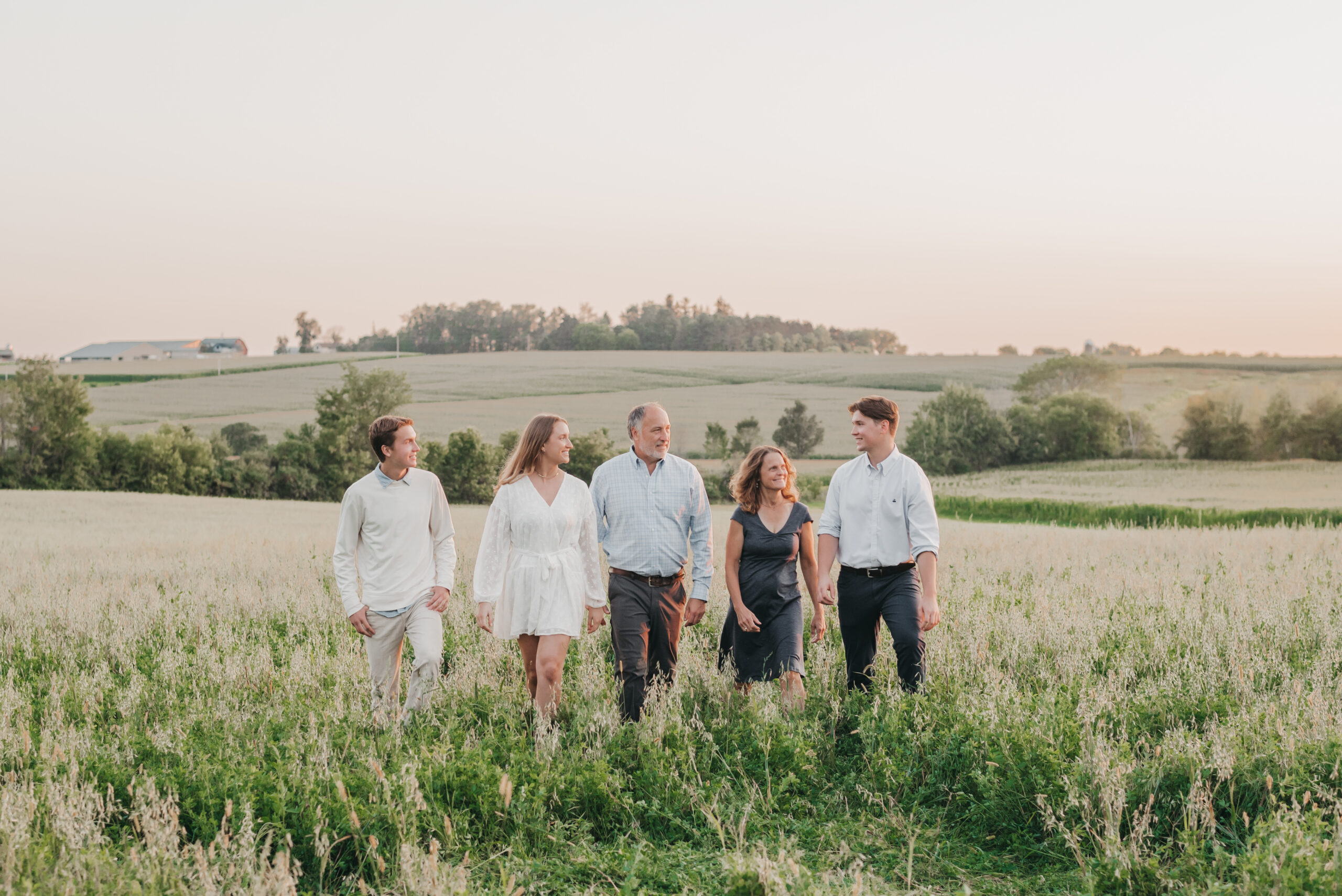 Posing families with older kids walking together during a golden hour outdoor family photography session
